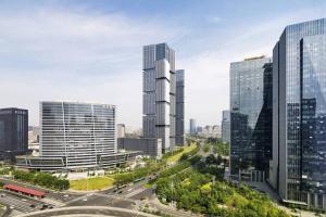 eine Skyline der Stadt mit hohen Gebäuden und einer Autobahn in der Unterkunft Courtyard by Marriott Zhengzhou East in Zhengzhou