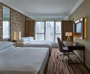 a hotel room with two beds and a desk at Dorsett Wanchai, Hong Kong in Hong Kong