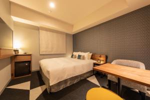 a hotel room with a bed and a table at Tokyu Stay Sapporo Odori in Sapporo