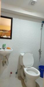 La salle de bains est pourvue de toilettes blanches et d'un lavabo. dans l'établissement Hondelz Budget Homestay, à Busuanga