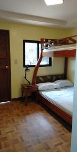 a bedroom with two bunk beds and a table with a lamp at Hondelz Budget Homestay in Busuanga