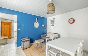 sala de estar con mesa blanca y pared azul en Awesome Home In Noirmoutier En Lile With Kitchen, en Noirmoutier-en-l'Île