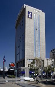 a large building with a blue and white sign on it at Hotel Regal Pacific Santiago in Santiago