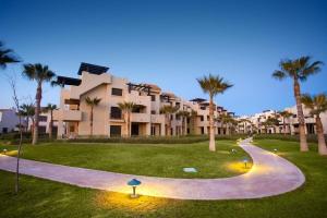un camino frente a un complejo con palmeras en Penthouse Apartment - Roda Golf & Beach Club, en San Javier