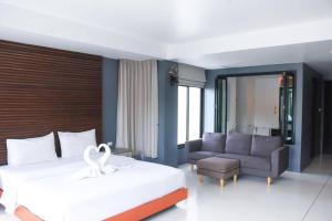 a hotel room with a bed and a couch at Coco boutique hotel in Patong Beach