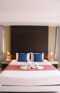 a large white bed with two towels on it at Coco boutique hotel in Patong Beach +37 photos