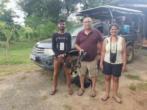 um grupo de três pessoas em pé na frente de um caminhão em Ceylon Resort Wilpattu em Parque Nacional Wilpattu