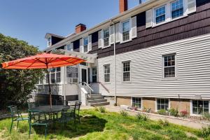 a table with an umbrella in front of a building at Warren Vacation Rental, Walk to Warren Town Beach in Warren
