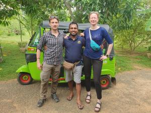 tres personas de pie delante de un coche verde en Ceylon Resort Wilpattu en Wilpattu
