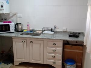 a kitchen counter with a sink and a microwave at El refugio in San Antonio de Areco