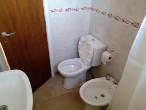 a small bathroom with a toilet and a sink at El refugio in San Antonio de Areco