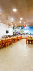 a dining room with tables and chairs and a mural at Hùng Đức Hotel Cửa Lò in Cửa Lô