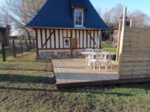 een hut met een tafel en stoelen op een terras bij Paisible Cahute in La Poterie-Mathieu +4 foto's