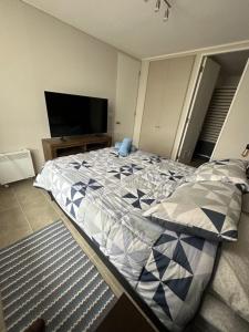 uma cama grande num quarto com televisão em Hermoso departamento full equipado centro de Temuco em Temuco