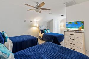 Un dormitorio con dos camas y un televisor de pantalla plana. en King 2 Queens 3 Doubles Foldout Stainless Steel Beach Gear included, en Hilton Head Island