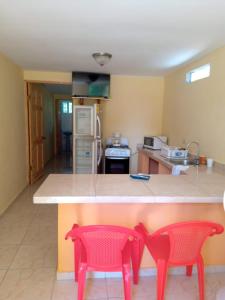 una cocina con 2 sillas rojas en un mostrador en Cabañas El Valle en Antón