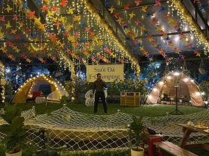 a woman standing in front of a tent with lights at Suối Đá F-Glamping 2026 in Thiện Giáo