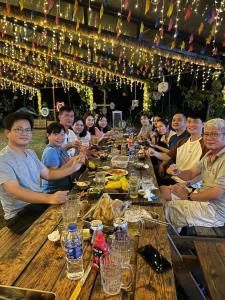 a group of people sitting around a long table at Suối Đá F-Glamping 2026 in Thiện Giáo