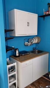 a kitchen with white cabinets and a sink at myPatong Social Hostel in Patong Beach