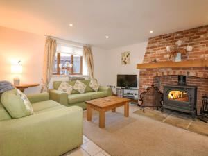 a living room with a couch and a fireplace at Hadleigh Farm Barn in Gayton
