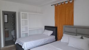 1 dormitorio con 2 camas y espejo en Casa Hospedaje Sandra en Aguachica