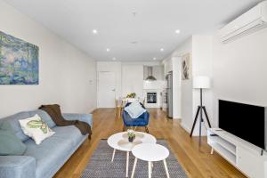 un soggiorno con divano e TV di Ambrosia - East End Hillside Haven a Adelaide