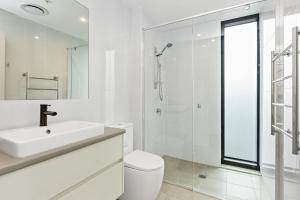 a white bathroom with a sink and a shower at Ambrosia - East End Hillside Haven in Adelaide