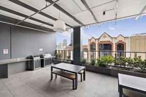 a living room with a table and a balcony at Ambrosia - East End Hillside Haven in Adelaide