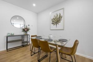a dining room with a table and chairs at Meadow - The York Skyline Apartment in Adelaide