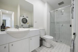 a bathroom with a sink and a toilet and a shower at Meadow - The York Skyline Apartment in Adelaide