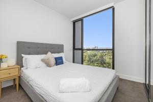 a bedroom with a bed and a large window at Oleria - Serene Bohem Retreat in Adelaide