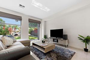a living room with a couch and a tv at Clover - The Split-Level Sanctuary in Payneham South in Norwood