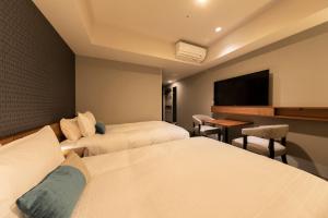 a hotel room with two beds and a flat screen tv at Tokyu Stay Sapporo Odori in Sapporo