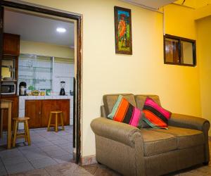 uma sala de estar com um sofá e uma cozinha em Cusco Hawka Pacha hostal em Cusco