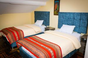 um quarto de hotel com duas camas num quarto em Cusco Hawka Pacha hostal em Cusco