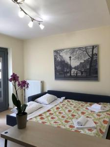 ein Schlafzimmer mit einem Bett mit einem Tisch und einem Bild in der Unterkunft Cozy cottage in Áyios Dhimítrios