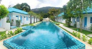 湄南海滩March Samui Resort的建筑物前的一个大型蓝色游泳池