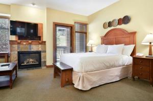a bedroom with a large bed and a fireplace at Sundial Lodge by Park City - Canyons Village in Park City