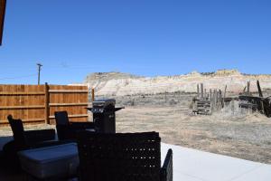 a patio with chairs and a grill in the desert at Log Cottages at Bryce Canyon #3 in Cannonville