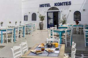 una fila de mesas y sillas en un restaurante en Hotel Kontes Comfort, en Parikia