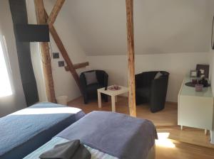 1 dormitorio con 2 camas, mesa y sillas en Grossvaters Haus - Oba's Heisle, en Lauingen