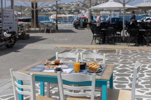 a blue table with a plate of food on it at Hotel Kontes Comfort in Parikia