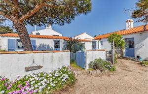 een wit huis met een hek en bloemen bij Beautiful Home In Noirmoutier En Lile With House Sea View in Noirmoutier-en-l'lle