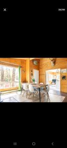 une salle à manger avec une table et des chaises blanches dans l'établissement Le petit Cottage du Grand Boisé, à Lac-Simon