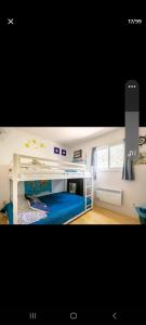 une chambre avec un lit superposé avec un lit bleu dans l'établissement Le petit Cottage du Grand Boisé, à Lac-Simon