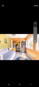 Habitación con cama y sala de estar. en Le petit Cottage du Grand Boisé, en Lac-Simon