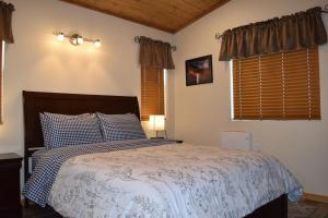a bedroom with a bed with a blue and white comforter at Log Cottages at Bryce Canyon #3 in Cannonville