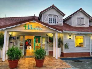 um edifício com vasos de plantas à sua frente em Hôtel Bambou & Spa em Les Trois-Îlets