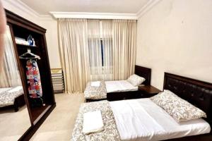 1 Schlafzimmer mit 2 Betten und einem großen Fenster in der Unterkunft Cozy 3 Bedroom Apartment Near 7th Circle in Amman