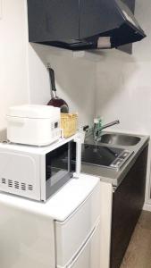 a kitchen with a sink and a microwave at ookubo! 大久保! 新宿步行距离! 精品新装公寓! 大久保车站步行7分钟! 干湿分离! 智能马桶! 高速无限制网路 201 in Tokyo
